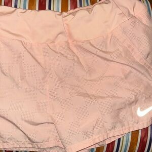 These are Nike dri-fit athletic shorts. They are pink. They are a size medium.